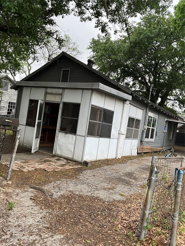rear view of property featuring fence