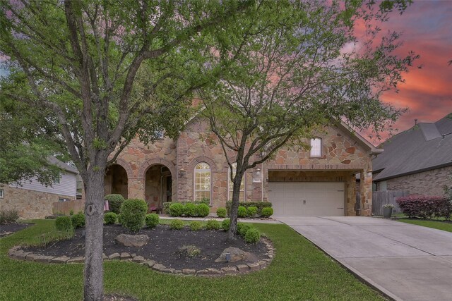 1915 Graystone Hills Dr, Conroe, TX 77304 - view of front facade with stone siding, concrete driveway, and a garage