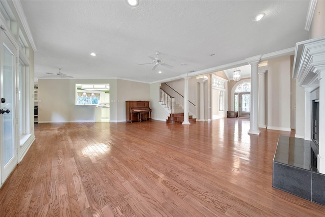 5 Briarwood Dr, Conroe, TX 77301 - unfurnished living room with ornamental molding, light wood-type flooring, a ceiling fan, ornate columns, and stairway