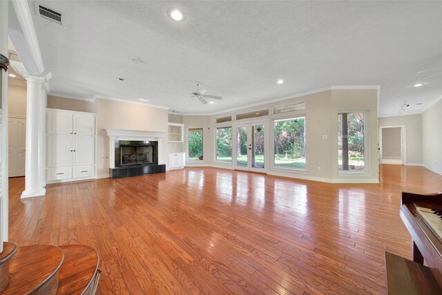 5 Briarwood Dr, Conroe, TX 77301 - unfurnished living room featuring light wood finished floors, ornate columns, and ceiling fan