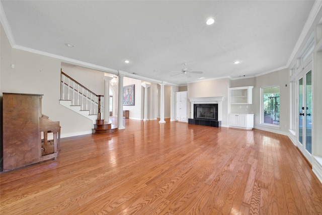 5 Briarwood Dr, Conroe, TX 77301 - unfurnished living room with light wood-type flooring, ceiling fan, a tiled fireplace, and ornamental molding