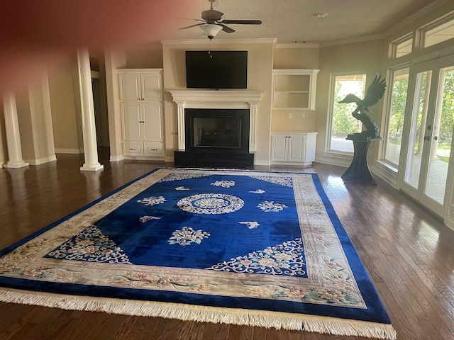 5 Briarwood Dr, Conroe, TX 77301 - unfurnished living room with a fireplace with raised hearth, a ceiling fan, a textured ceiling, crown molding, and hardwood / wood-style floors