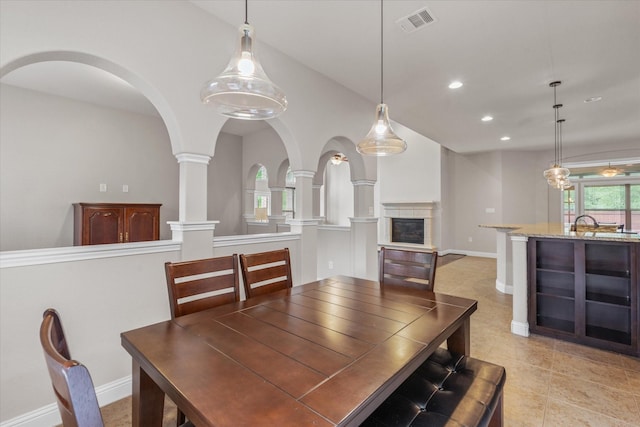dining space with a glass covered fireplace, visible vents, recessed lighting, light tile patterned flooring, and baseboards