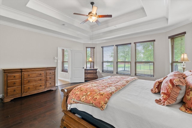 bedroom with a raised ceiling, ornamental molding, ceiling fan, and dark wood finished floors