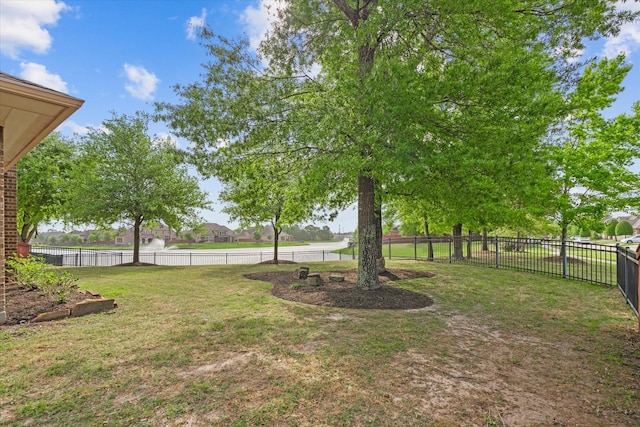 view of yard featuring a water view and fence