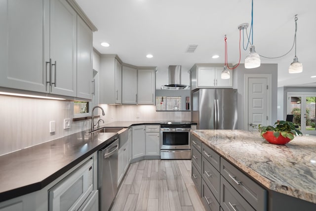 kitchen featuring a sink, wall chimney range hood, recessed lighting, stainless steel appliances, and gray cabinets