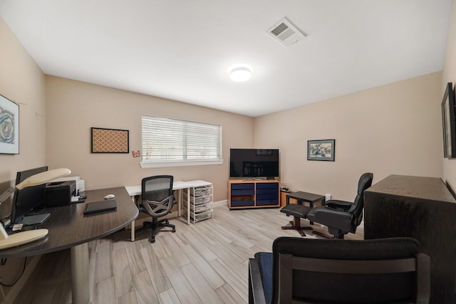 office space featuring light wood-type flooring and visible vents