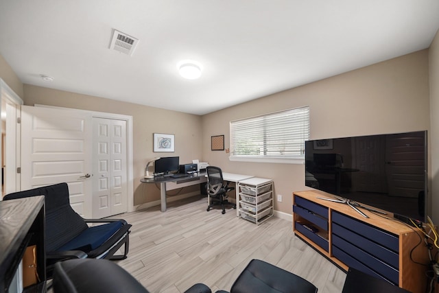 office area featuring visible vents, baseboards, and light wood-style flooring
