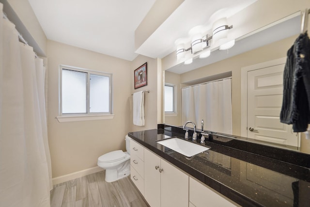 full bathroom with vanity, baseboards, and toilet
