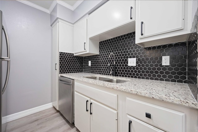 kitchen with ornamental molding, a sink, stainless steel appliances, and backsplash
