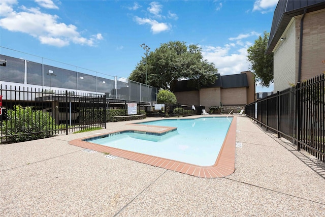 community pool featuring fence and a patio area