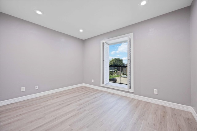 empty room featuring light wood-style floors, baseboards, and recessed lighting