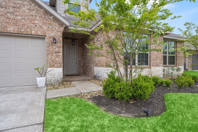 entrance to property featuring brick siding and a garage
