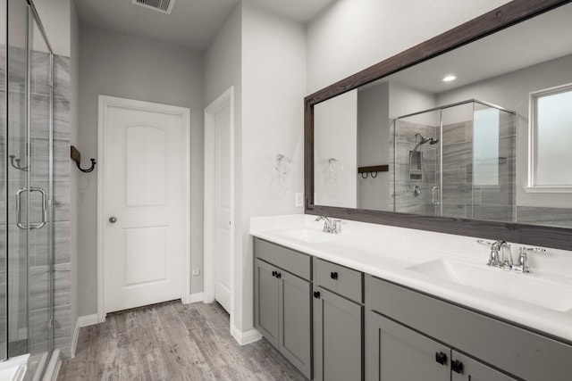 12627 Beddington Ct, Tomball, TX 77375 - bathroom with a stall shower, double vanity, and wood finished floors