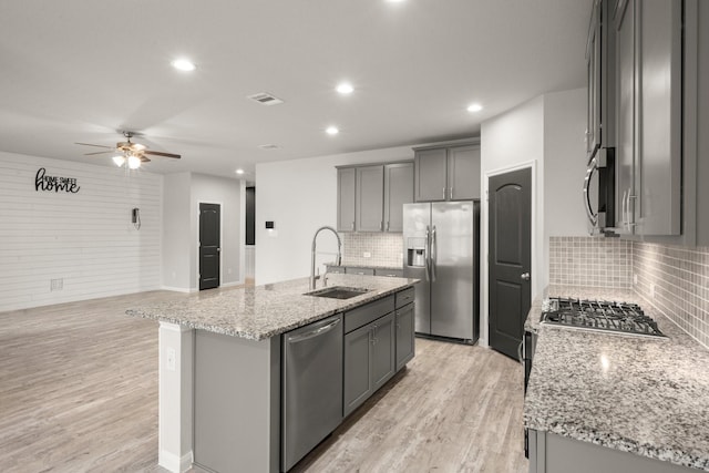 12627 Beddington Ct, Tomball, TX 77375 - kitchen with appliances with stainless steel finishes, a sink, ceiling fan, light wood-style flooring, and recessed lighting