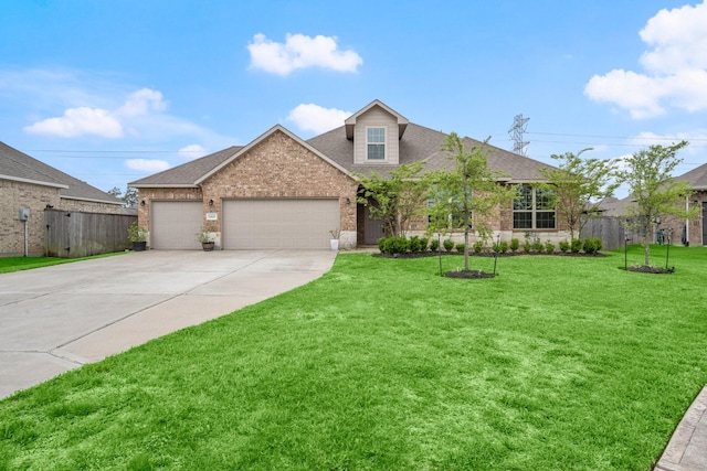 view of front facade with fence, an attached garage, driveway, brick siding, and a front yard