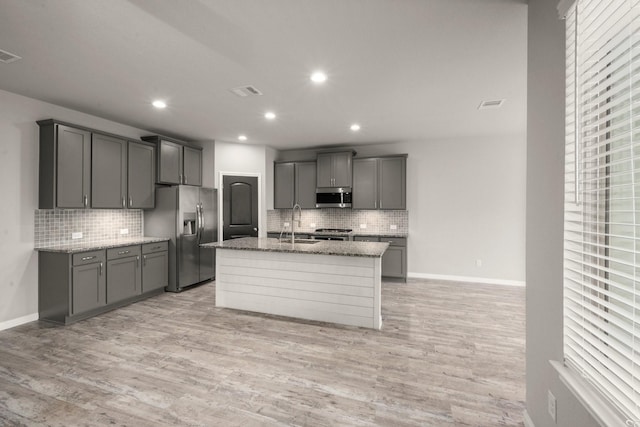 12627 Beddington Ct, Tomball, TX 77375 - kitchen with appliances with stainless steel finishes, decorative backsplash, gray cabinetry, light stone countertops, and a sink