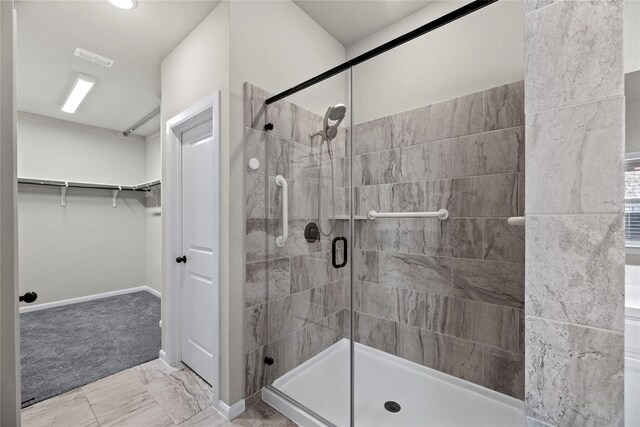 full bathroom featuring visible vents, a walk in closet, baseboards, and a shower stall