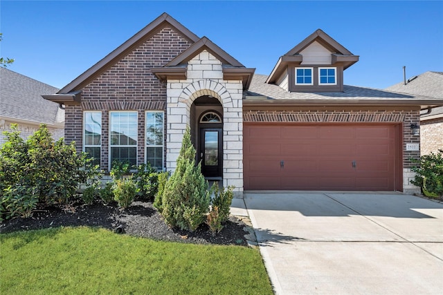 view of front of property with stone siding, a garage, brick siding, and concrete driveway