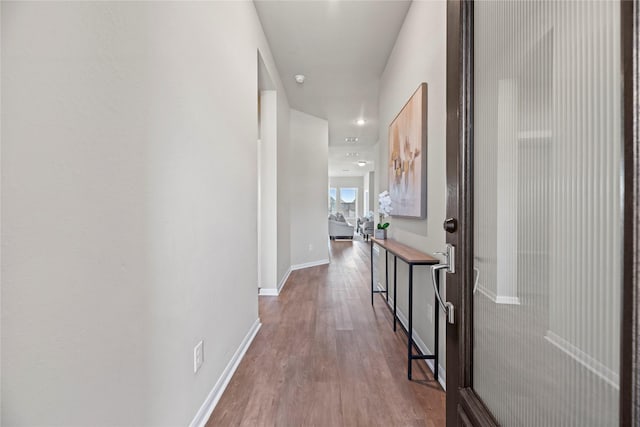 hallway with recessed lighting, baseboards, and wood finished floors
