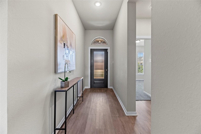 entryway with a textured wall, baseboards, and dark wood finished floors