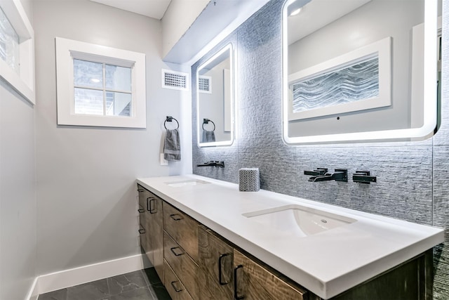 2415 Church St, Galveston, TX 77550 - bathroom featuring double vanity, a sink, baseboards, and visible vents