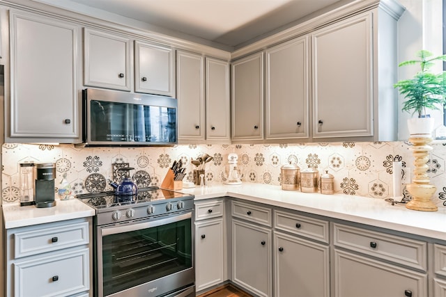 2415 Church St, Galveston, TX 77550 - kitchen featuring gray cabinets, light countertops, decorative backsplash, and appliances with stainless steel finishes