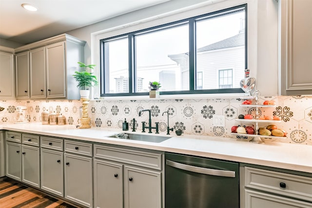 2415 Church St, Galveston, TX 77550 - kitchen with decorative backsplash, light countertops, dishwasher, a sink, and gray cabinetry