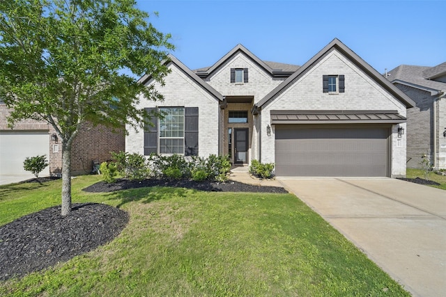 7323 Perching Hawk Trl, Katy, TX 77493 - french country inspired facade with concrete driveway, a front yard, a standing seam roof, and brick siding