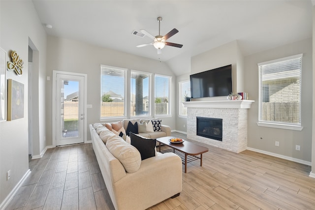 7323 Perching Hawk Trl, Katy, TX 77493 - living area featuring light wood-type flooring, ceiling fan, baseboards, and a stone fireplace