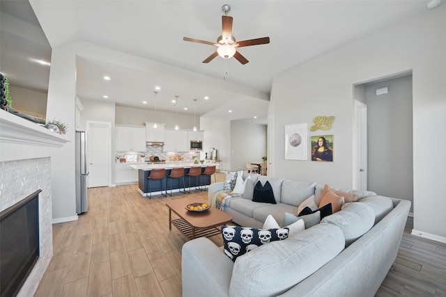 7323 Perching Hawk Trl, Katy, TX 77493 - living area with a glass covered fireplace, baseboards, recessed lighting, light wood-style floors, and ceiling fan