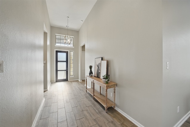 7323 Perching Hawk Trl, Katy, TX 77493 - foyer featuring a notable chandelier, a towering ceiling, wood finish floors, and baseboards