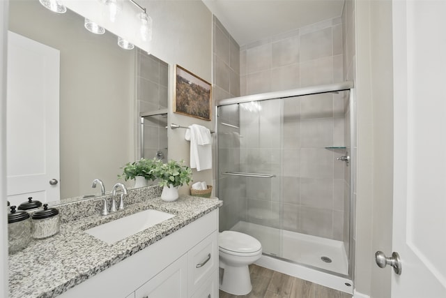 7323 Perching Hawk Trl, Katy, TX 77493 - full bath featuring toilet, vanity, a stall shower, and wood finished floors