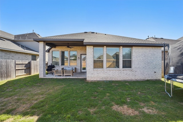 7323 Perching Hawk Trl, Katy, TX 77493 - rear view of property with ceiling fan, a trampoline, a lawn, a fenced backyard, and a patio
