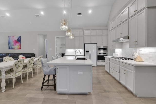 5119 Long Branch Bnd, Fulshear, TX 77441 - kitchen featuring appliances with stainless steel finishes, a sink, under cabinet range hood, high vaulted ceiling, and backsplash