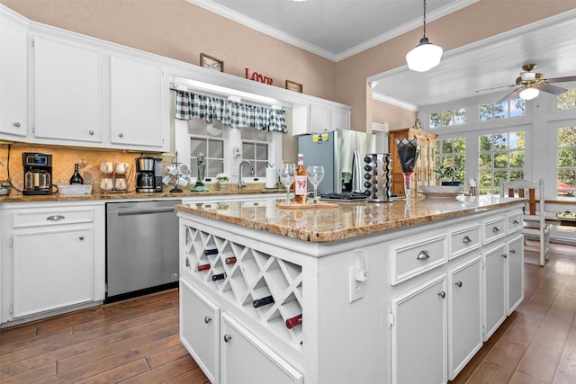 712 Lamar Ave, Crockett, TX 75835 - kitchen with white cabinetry, ornamental molding, stainless steel appliances, dark wood-type flooring, and decorative backsplash