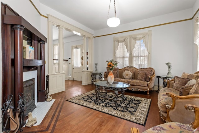 712 Lamar Ave, Crockett, TX 75835 - living area with wood finished floors, a fireplace, and ornate columns