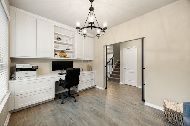 16875 Olympic National Dr, Humble, TX 77346 - office area with built in study area, light wood-style flooring, a chandelier, and baseboards