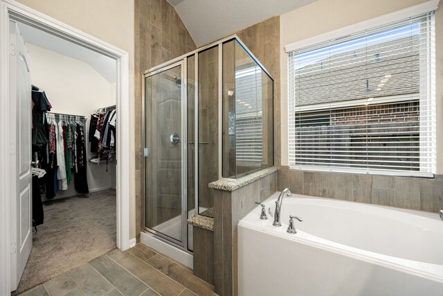 16875 Olympic National Dr, Humble, TX 77346 - bathroom with a bath, a stall shower, a spacious closet, lofted ceiling, and wood finished floors