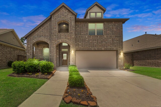 16875 Olympic National Dr, Humble, TX 77346 - view of front of house featuring brick siding, an attached garage, concrete driveway, and a yard