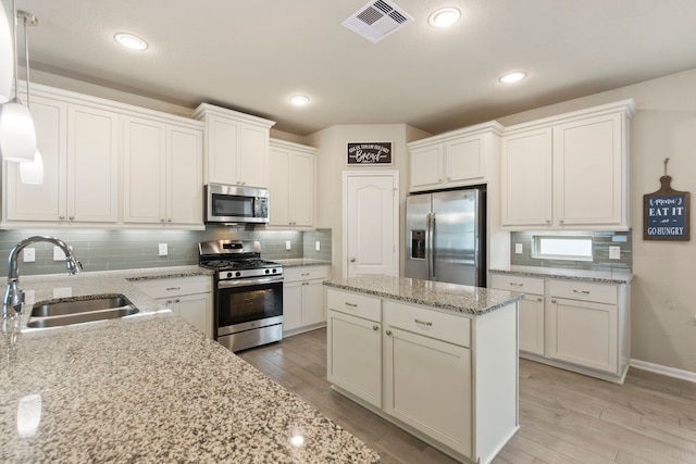 16875 Olympic National Dr, Humble, TX 77346 - kitchen with stainless steel appliances, a sink, decorative backsplash, light wood finished floors, and recessed lighting