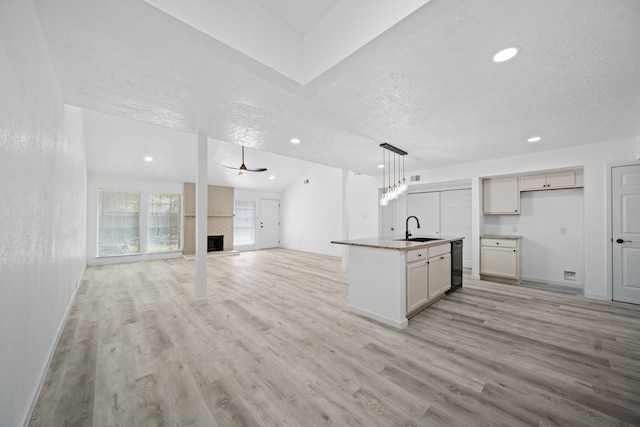 19207 Woodglen Dr, Katy, TX 77449 - kitchen featuring a sink, a textured ceiling, open floor plan, light wood-type flooring, and black dishwasher