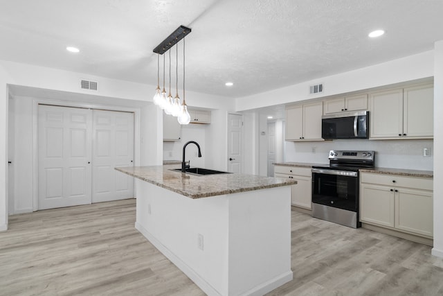 19207 Woodglen Dr, Katy, TX 77449 - kitchen with visible vents, light wood finished floors, a sink, and appliances with stainless steel finishes