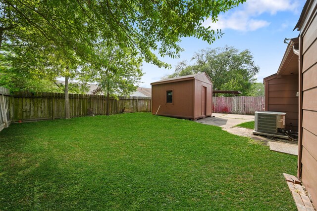 19207 Woodglen Dr, Katy, TX 77449 - view of yard with a fenced backyard, a storage unit, an outdoor structure, and central AC unit