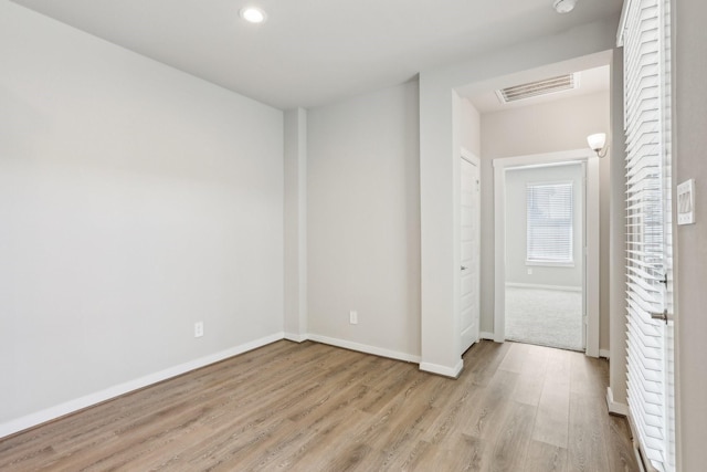 unfurnished room with wood finished floors, baseboards, and recessed lighting