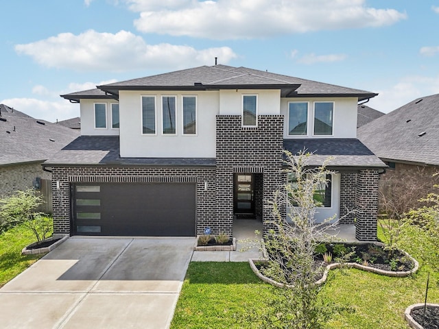 prairie-style house with stucco siding, brick siding, an attached garage, concrete driveway, and roof with shingles