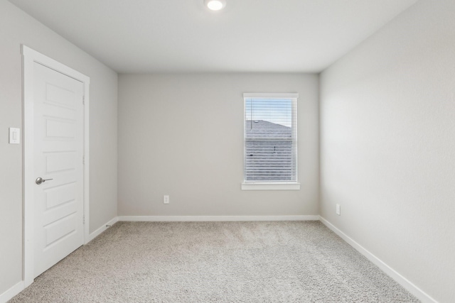 empty room with light colored carpet and baseboards
