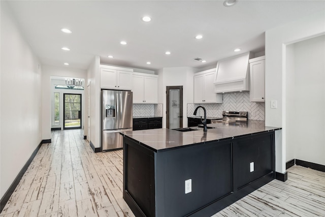 24717 Sligo St, Hempstead, TX 77445 - kitchen featuring white cabinets, a peninsula, premium range hood, appliances with stainless steel finishes, and a sink