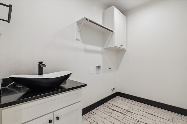 24717 Sligo St, Hempstead, TX 77445 - clothes washing area with a sink, electric dryer hookup, baseboards, cabinet space, and hookup for a washing machine