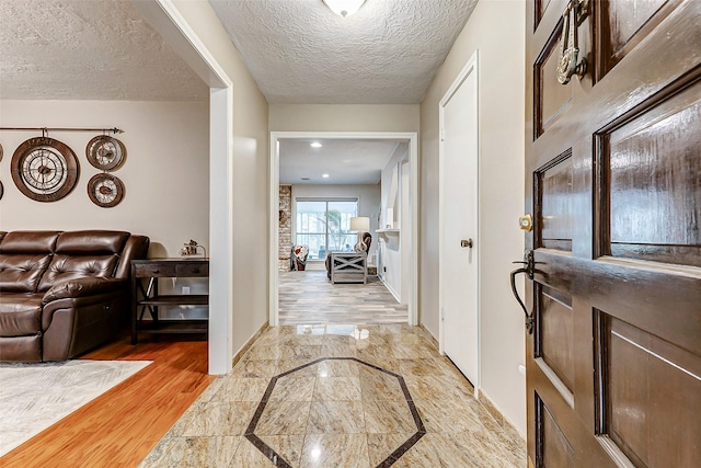 22814 Wren Ln, Tomball, TX 77377 - foyer with inlaid floor details, baseboards, a textured ceiling, and light marble finish flooring